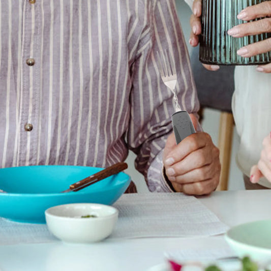 Weighted anti-tremor spoon in use — reduces hand shake for independent eating
